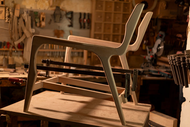 Chair being assembled with clamps in a workshop setting
